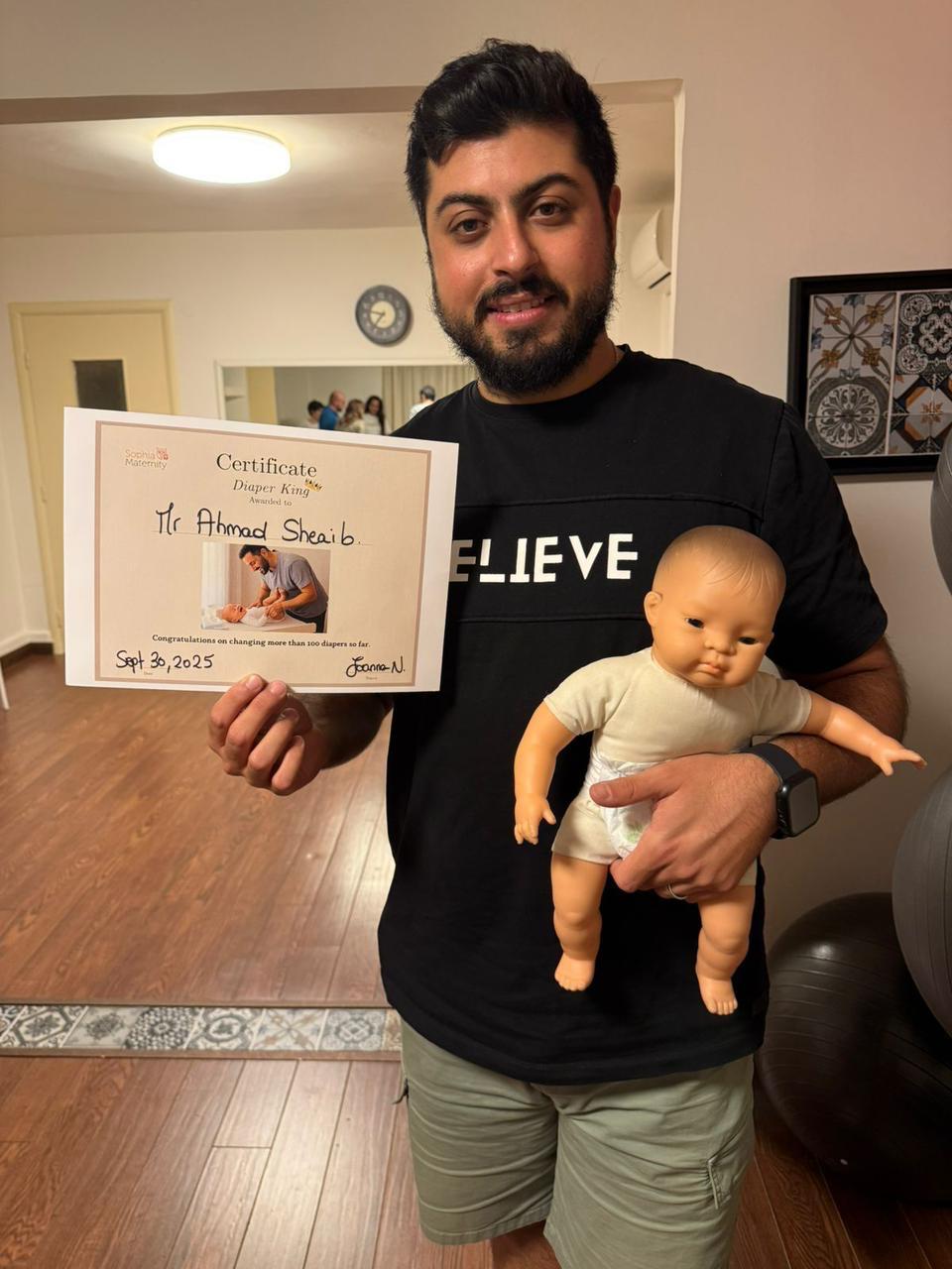 Proud parent receiving a Diaper King certificate at Sophia Maternity